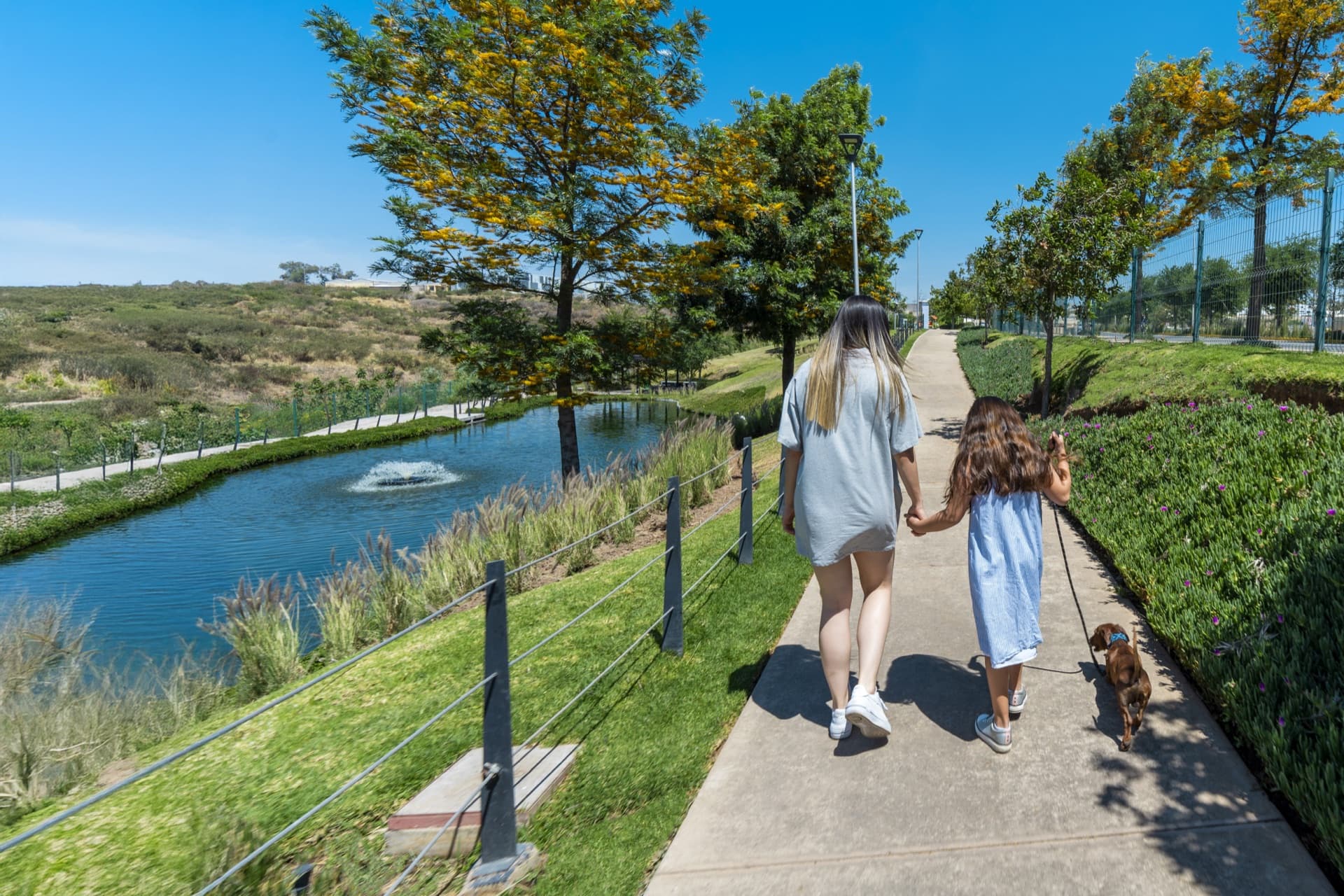 Capital Norte: familia paseando por las áreas verdes y el lago de la comunidad